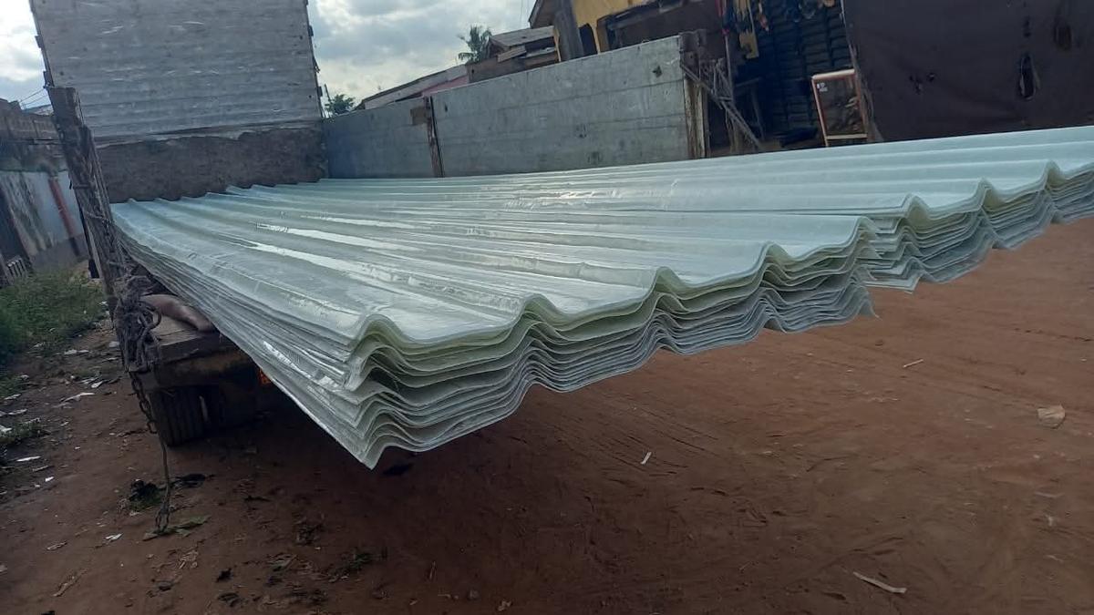 Large bulk order of clear corrugated fibre glass roofing sheets stacked on a truck bed